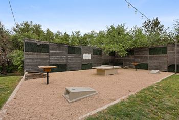 A backyard with a sandbox and a wooden fence.